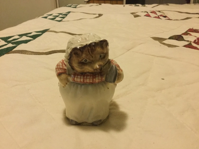 A china figurine of a hedgehog in an apron holding an iron.